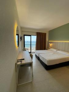 een hotelkamer met 2 bedden en een tafel bij Hotel Marconi in Benidorm