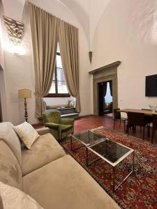 sala de estar con sofá y mesa en Palazzo Roselli Cecconi Apartments, en Florencia