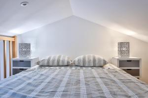 1 dormitorio blanco con 1 cama con 2 mesitas de noche en Studio Le Petit Julien, en Saint-Julien-des-Landes