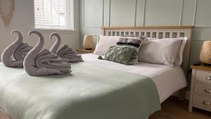 a bedroom with two swans pillows on a bed at Harbourside, Luxurious Elegant Holiday home with Bike store - Sleeps 6 in Wick