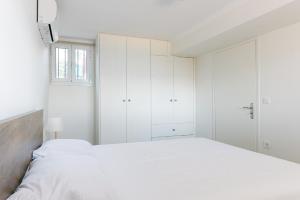 a white bedroom with white cabinets and a bed at Rodini House in Kato Rodini