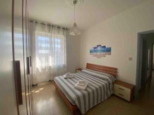 a bedroom with a bed with two towels on it at la casa di Alice in Vercelli
