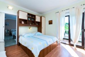 a bedroom with a bed and a large window at Apartments Mrijana D in Barbat na Rabu