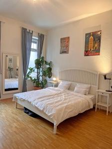 a bedroom with a large white bed and a window at Mediterrane EG-Wohnung / BASF-Nähe / 650mbit WLAN in Ludwigshafen am Rhein