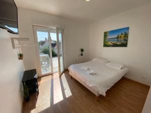 ein Schlafzimmer mit einem Bett und einem großen Fenster in der Unterkunft Appartement 10pers. à Vallères in Vallères