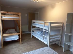 Condé-sur-NoireauにあるGîtes de L'Aumondièreの二段ベッド2台とベッド1台が備わる客室です。