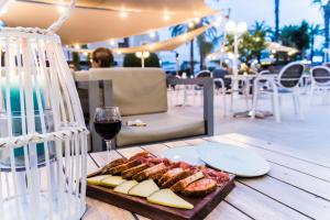a table with a plate of food and a glass of wine at Hotel Planas in Salou