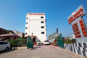 a white building with cars driving on a street at HOTEL ANAND INTERNATIONAL in Bodh Gaya