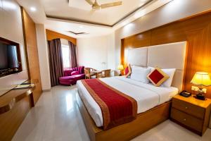 a hotel room with a bed and a tv at HOTEL ANAND INTERNATIONAL in Bodh Gaya