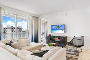 uma sala de estar com um sofá branco e uma televisão em Luxury Well stocked SE Corner 2BR W Fort Lauderdale w Great Ocean Views em Fort Lauderdale