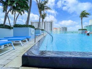 ein Pool auf dem Dach eines Gebäudes mit Palmen in der Unterkunft Luxury Well stocked SE Corner 2BR W Fort Lauderdale w Great Ocean Views in Fort Lauderdale