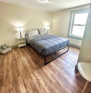 Schlafzimmer mit einem Bett und Holzboden in der Unterkunft 2BR Sunshine Town Condo in Newport