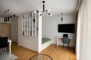 uma sala de estar com uma secretária e uma televisão em EXCLUSIVE Apartamenty Lotnicza , PARKING em Kielce