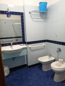 baño azul y blanco con aseo y lavamanos en Residence Oltremare, en San Benedetto del Tronto