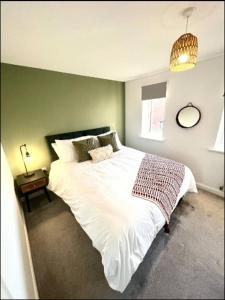 a bedroom with a large white bed and a table at Broad Acre House - Nr Racecourse in Cheltenham