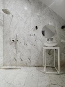 Baño blanco con lavabo y espejo en Cisowy Zakątek en Sasino