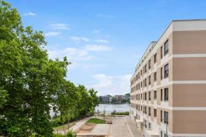 ein Apartmenthaus mit einem Fluss im Hintergrund in der Unterkunft Habyt-The Waterfront in Berlin