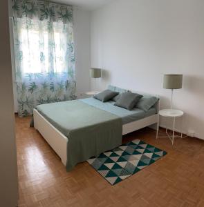 um quarto com uma cama grande e 2 janelas em CASA DENDI em Trieste