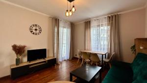 een woonkamer met een bank en een tafel bij Mala Italia Apartments in Wrocław