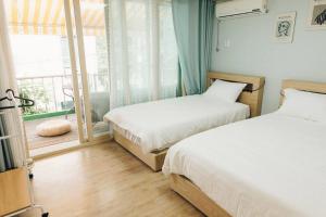 1 dormitorio con 2 camas y ventana con vistas en Hongdae Luxury Private Single House with Big Open Balcony Perfect for a Family & Big Group 3BR, 5QB & 1SB, 2Toilet en Seúl