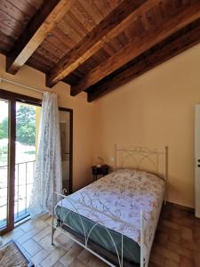 a bedroom with a bed and a large window at Luci nel Bosco 