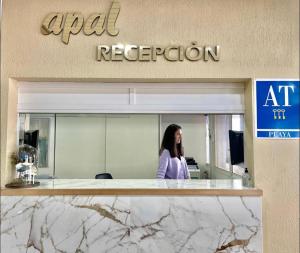 Eine Frau steht vor einem Büro. in der Unterkunft Apartahotel CHINASOL con Parking y Desayuno in Almuñécar