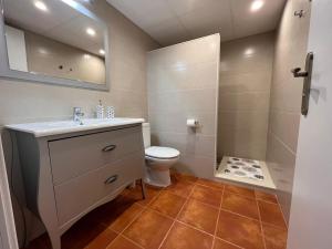 een badkamer met een toilet, een wastafel en een spiegel bij Ca la Beata in Cálig