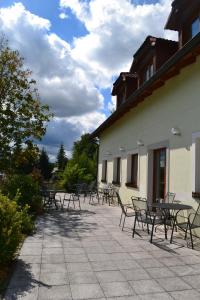 a group of tables and chairs next to a building at Apartmán Benešovka in Vacov +1 photo
