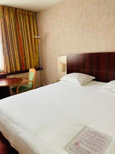 ein Hotelzimmer mit einem Bett mit Schild darauf in der Unterkunft Mercure Besancon Parc Micaud - Hotel & Bar in Besançon