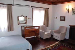 1 dormitorio con cama, escritorio y silla en Cunda adasında rum evi, en Ayvalık