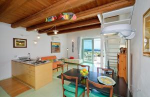 a kitchen and living room with a table and chairs at Petrantica Resort in Marina di Ragusa