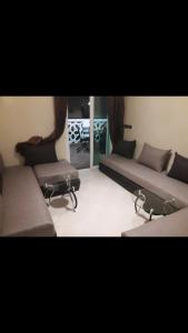 sala de estar con 2 camas y ventana en Appartement avec piscine Mohamedia 2chambres, en Mohammedia