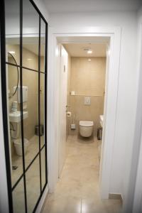 a bathroom with a toilet and a glass doorway at Pansion Blue Medjugorje in Međugorje