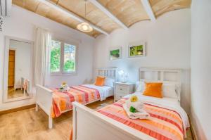 dwa łóżka w pokoju z dwoma oknami w obiekcie Ideal Property Mallorca - Sol de Mallorca 2 w Cala Mesquida
