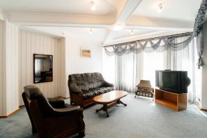 a living room with a couch and a television at Dacia Hotel in Chişinău