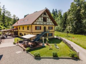 uma grande casa amarela com um alpendre e um pátio em Balzerberg em Weiler-Simmerberg
