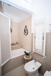 a white bathroom with a tub and a sink at Welcome Ostuni b&b in Ostuni