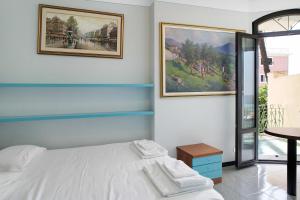 - une chambre avec un lit et deux photos sur le mur dans l'établissement Capriccio, à Bordighera