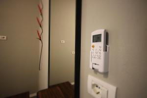 a phone is attached to the door of a room at Alyvia Rooms in Himare