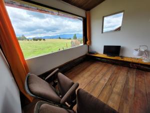 una camera con sedie e una finestra con vista su un campo di Finca La Aurora a Tibasosa