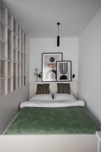 biała sypialnia z łóżkiem z zielonym dywanem w obiekcie EXCLUSIVE Apartamenty Lotnicza , PARKING w Kielcach