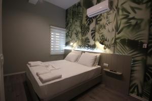 a small bed with white sheets and towels on it at Alyvia Rooms in Himare