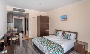Aparthotel Royal Marina Beach في تشيرنوموريتس: غرفة نوم بسرير وطاولة ومطبخ