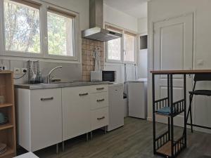 una cocina con armarios blancos y fregadero en lili, en La Seyne-sur-Mer