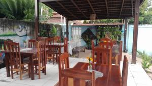 um restaurante ao ar livre com mesas e cadeiras de madeira em Pedra do Sol Pousada em Alter do Chão
