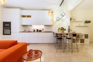 a kitchen and living room with a couch and a table at Sonnino House in Cagliari