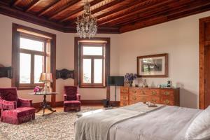 a bedroom with a bed and two chairs and a table at Chalet Ficalho in Cascais