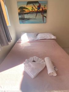 a white bed with a pillow and a towel on it at Pedra do Sol Pousada in Alter do Chao