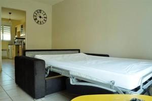 uma cama de hospital num quarto com um relógio na parede em Maison St Eloi by iZiLi *Futuroscope*Jardin* em Poitiers