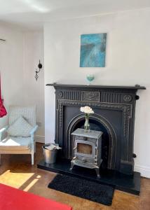 萊特肯尼的住宿－LOCH CONNELL LODGE，客厅设有黑色壁炉,配有花瓶